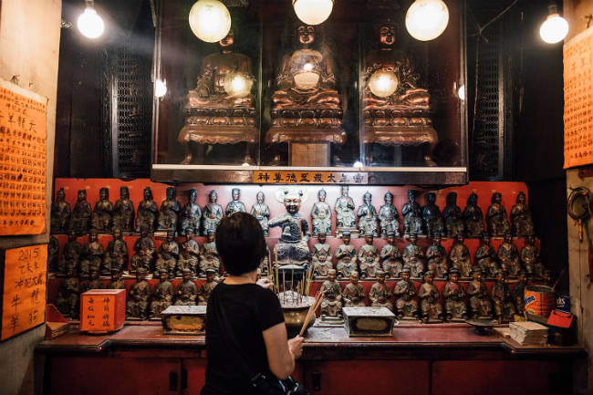 Una mujer lleva incienso como ofrenda a un altar del Kwong Fuk Ancestral Hall. Photo by Anthony Kwan/Getty Images for Hong Kong Images