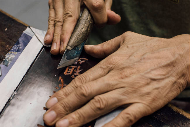 Graban una tableta para los ancestros, utilizada en los altares para venerar a los muertos. Photo by Anthony Kwan/Getty Images for Hong Kong Images