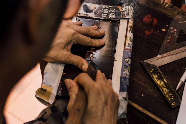 Graban una tableta para los ancestros, utilizada en los altares para venerar a los muertos. Photo by Anthony Kwan/Getty Images for Hong Kong Images